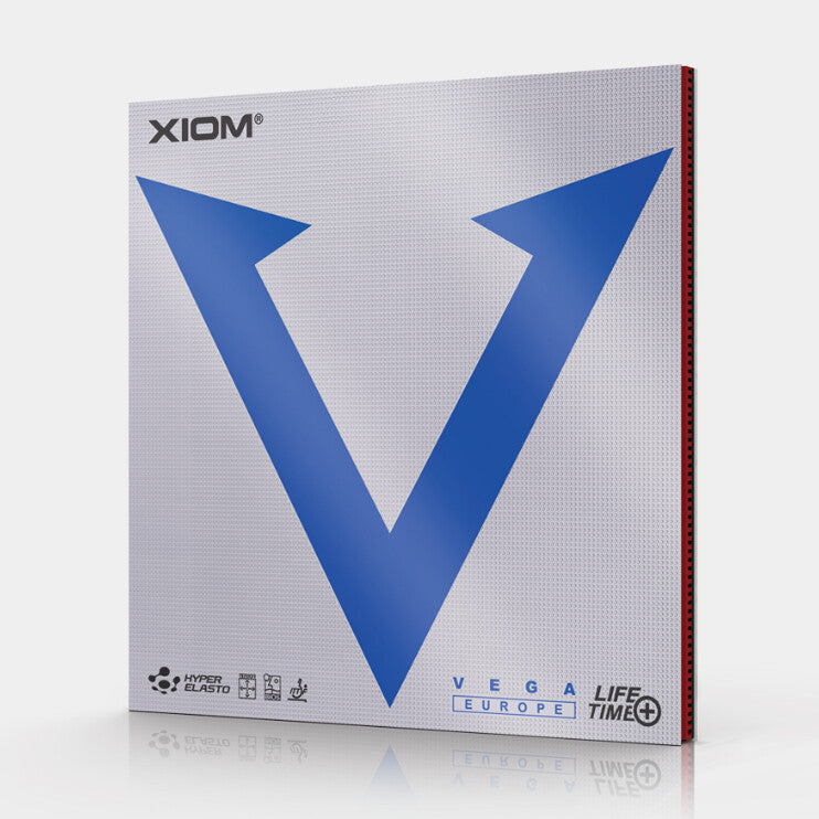 Xiom Vega Life Time+ table tennis rubber in Hyper Elastic, shown in its retail packaging box. The box features a textured silver-gray background with a large blue 'V' logo, the Xiom brand name, and the VEGA LIFE TIME+ text at the bottom.