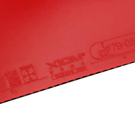 Close-up of a red table tennis rubber with embossed markings including the brand XIGM and model details, shown against a white background.